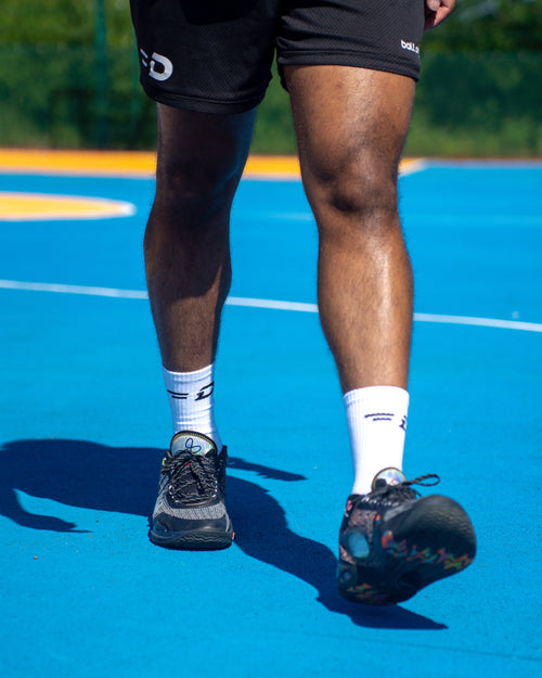 Player wearing Ball Driven socks and shorts on an outdoor basketball court